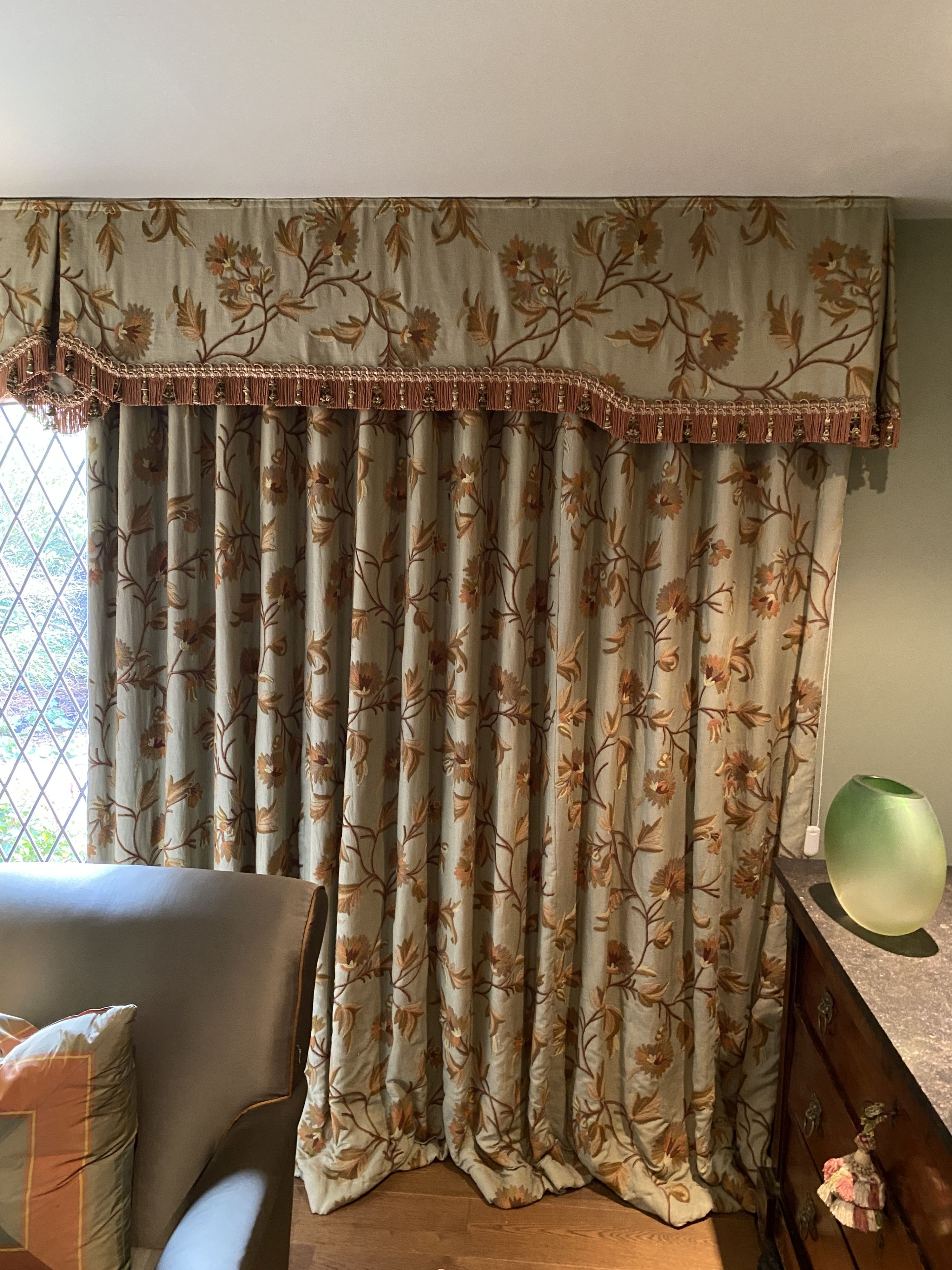 A pair of eau de nil linen curtains with floral crewel work decoration, and matching two piece pelmet, drop 230cm, generously made to fit an aperture of 3.8m